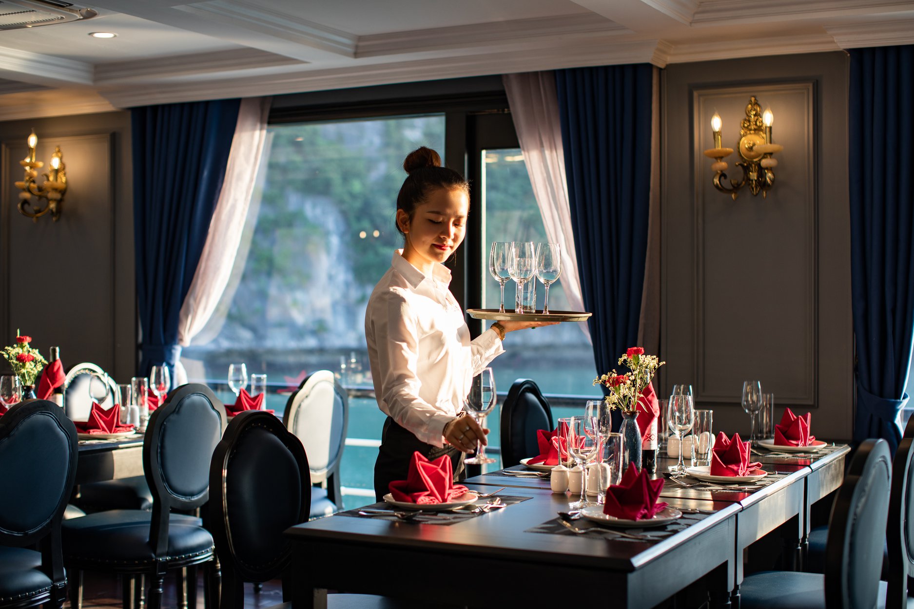Rosy cruise - Du thuyền 5 sao vịnh Lan Hạ 3 Nhân viên nhà hàng cẩn thận tỉ mỉ đặt từng chiếc ly để setup bàn chuẩn bị cho bữa tối trên tàu ngủ đêm 5 sao